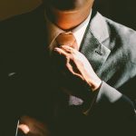 Man Wearing Suit Adjusting Necktie